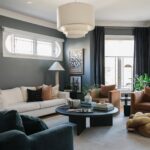 Blog post features image of Candace Mary Interiors space. Room is a moody slate blue painted walls, with a cream, and blue sofa and cognac accent chairs.